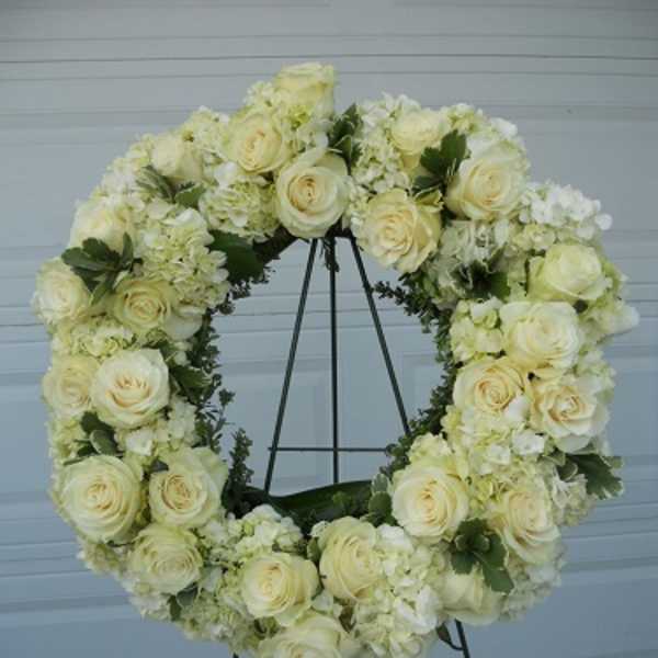 Cream rose and hydrangea wreath on a metal stand