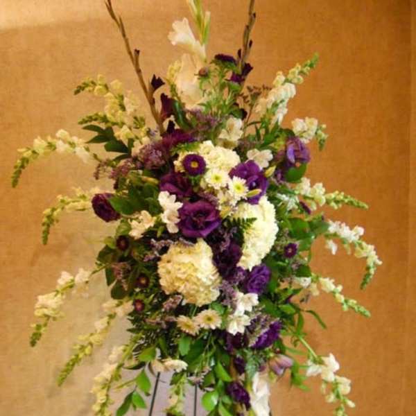 Tall floral spray with purple and white flowers on a stand