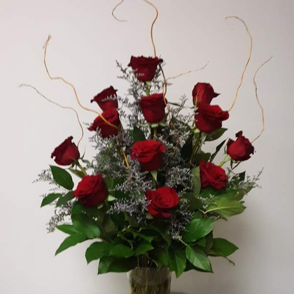 Tall bouquet of red roses in a clear glass vase