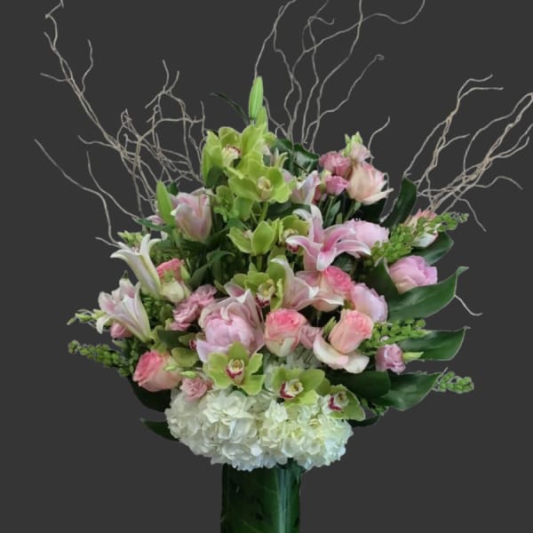 Pink and white floral arrangement in a tall green vase