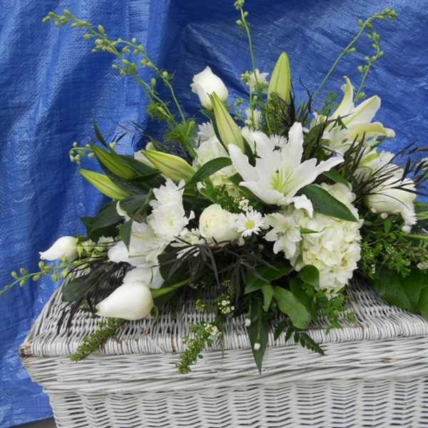 White floral arrangement in a white wicker basket