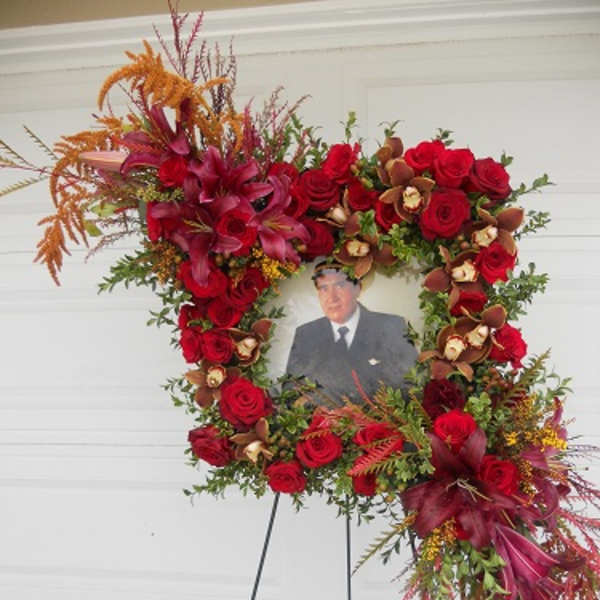 Standing floral wreath with red roses around a portrait photo