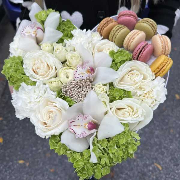 Heart-shaped bouquet with white roses, orchids, and macarons