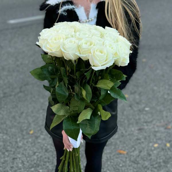 Bouquet of white roses with long stems and green leaves