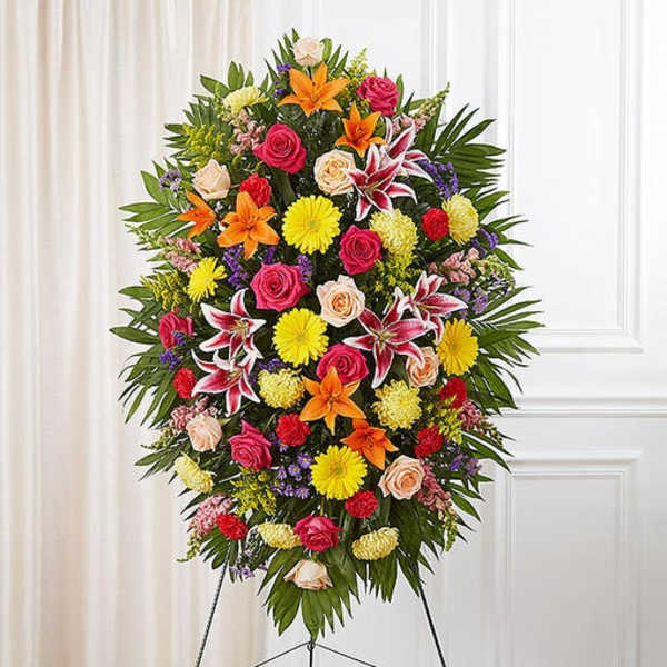 Large standing floral spray with mixed bright flowers on an easel