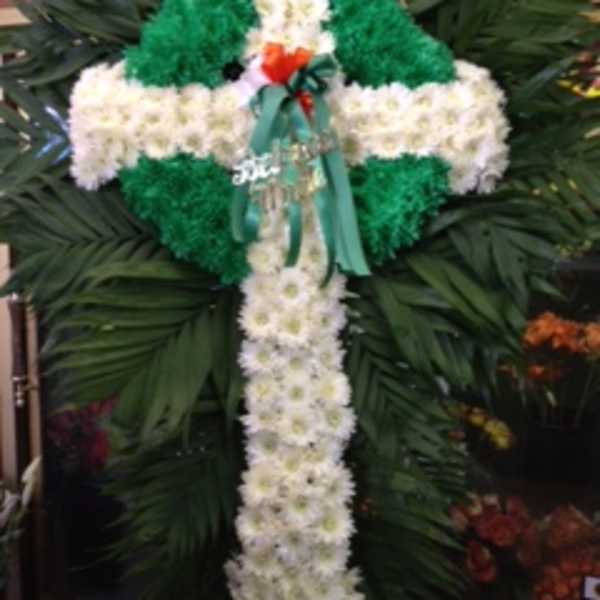 White and green floral cross arrangement with a ribbon bow