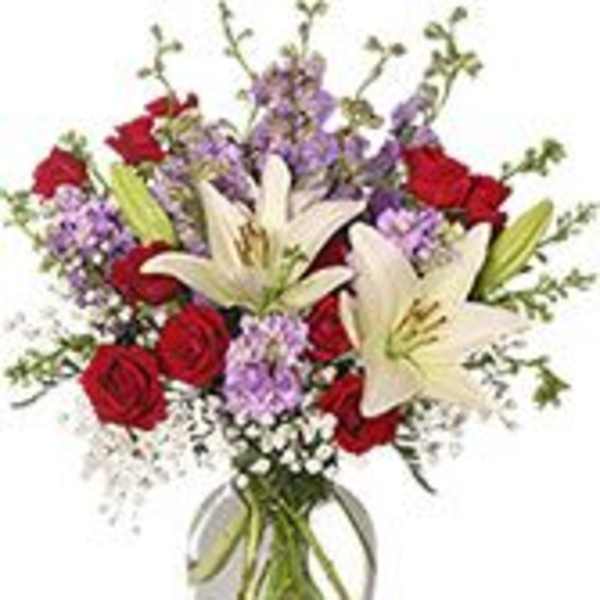 Bouquet of red roses and white lilies in a clear glass vase