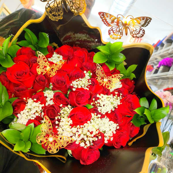 Bouquet of red roses with white filler and butterfly decorations