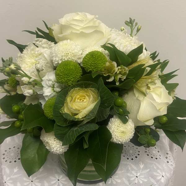 White and green floral arrangement in a glass vase
