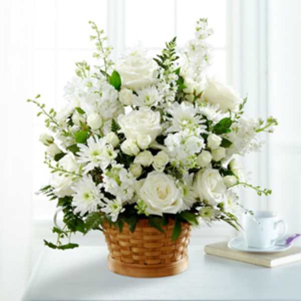 White roses and daisies arranged in a woven basket