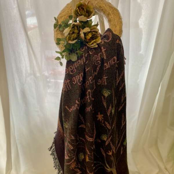 Floral wreath with yellow blooms and greenery on a draped shawl