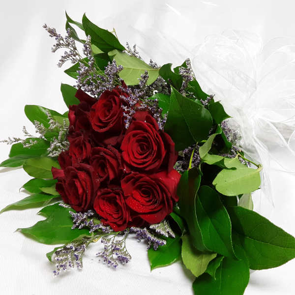 Bouquet of red roses with purple filler and a white ribbon bow