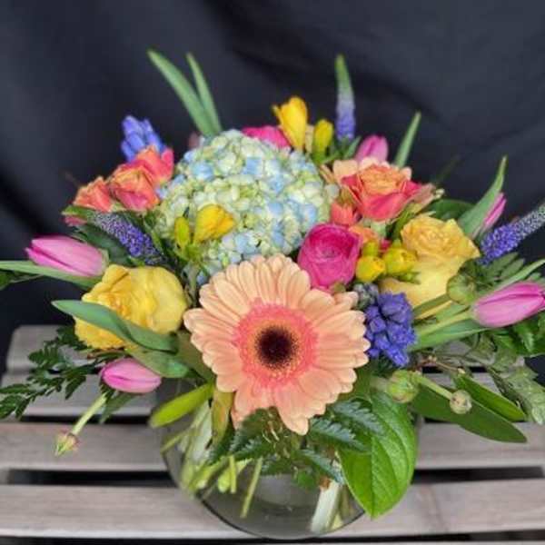 Mixed bouquet with a peach gerbera daisy in a glass vase