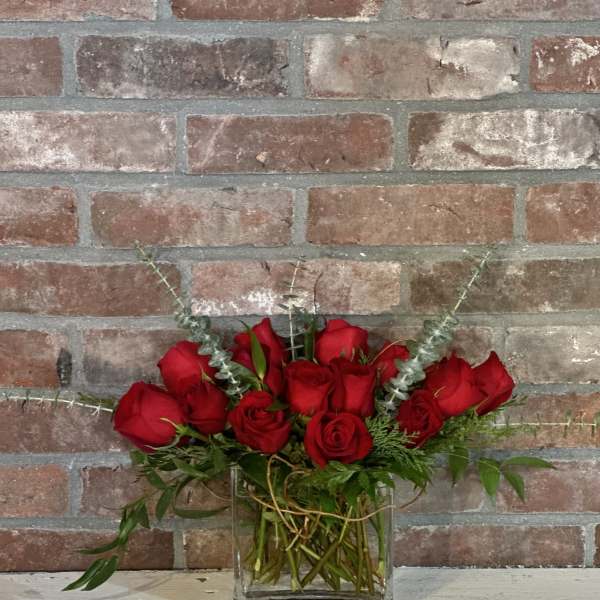 Red roses arranged in a clear glass vase