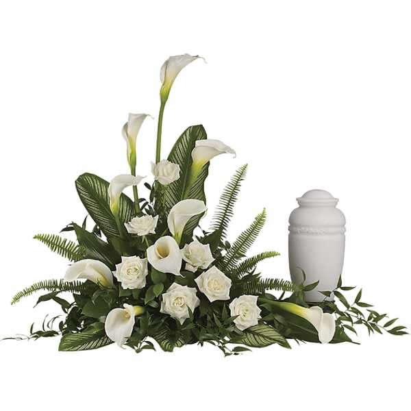 White calla lilies and roses arranged beside a white urn