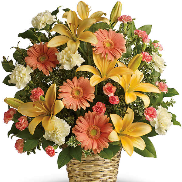 Mixed bouquet of yellow lilies, peach gerbera daisies, and white carnations in a woven basket