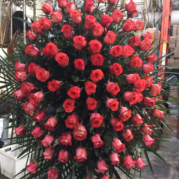 Large standing spray of red roses with palm fronds