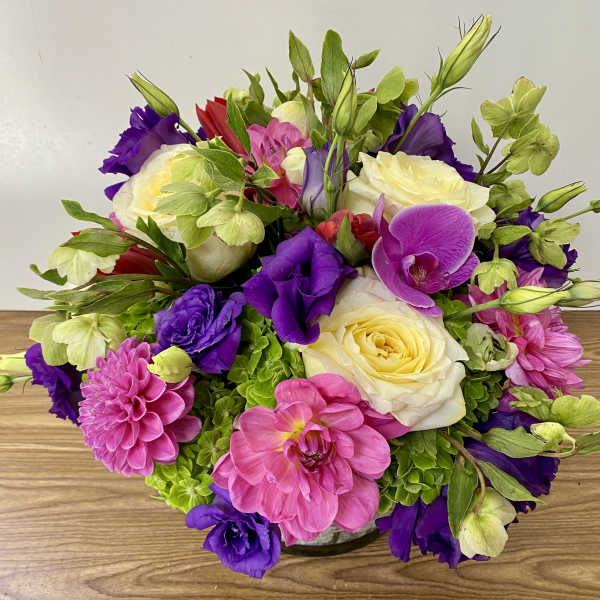 Bouquet of pink, purple, and white flowers in a low vase
