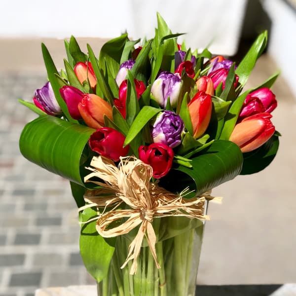 Bouquet of multicolored tulips in a clear glass vase
