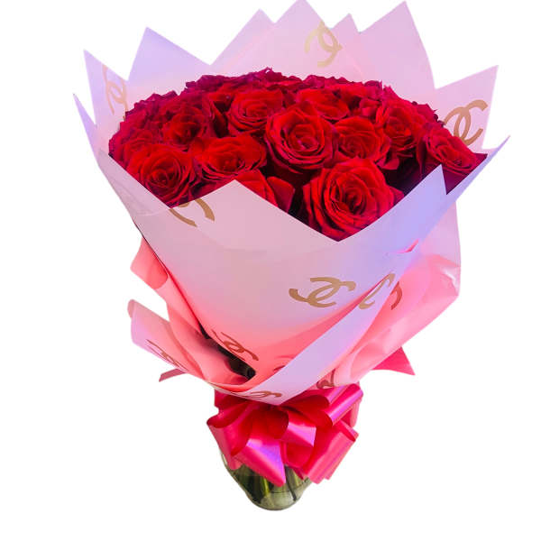 Bouquet of red roses wrapped in pink paper with a ribbon