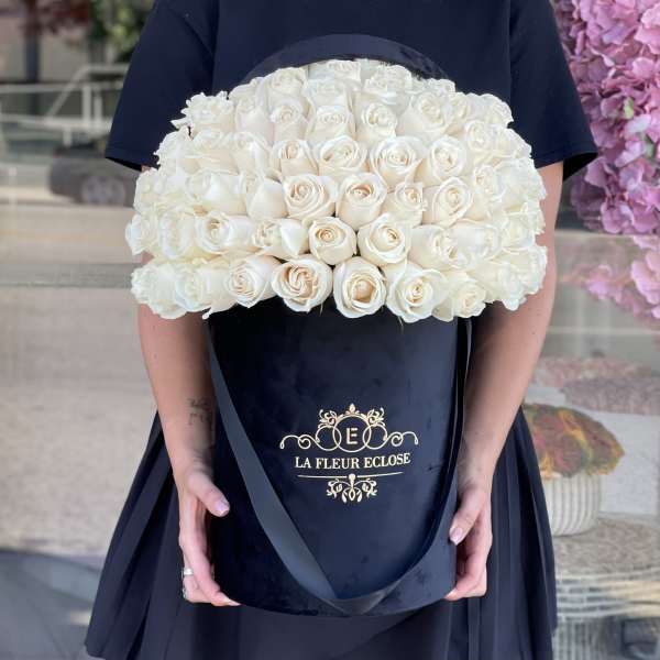 Large bouquet of white roses in a black hatbox