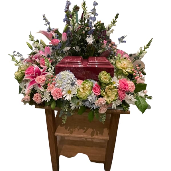 Large floral arrangement around a red casket