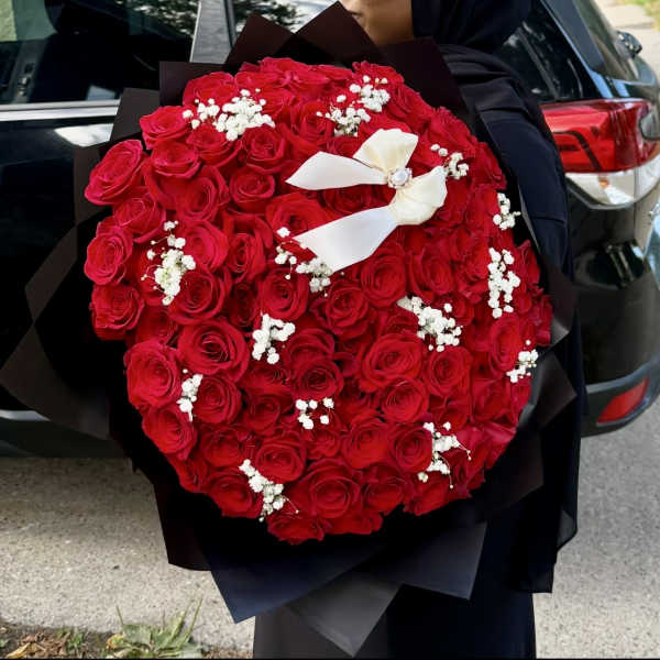 Large bouquet of red roses with white baby's breath and a white ribbon