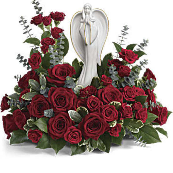 Red roses arranged around a white angel statue