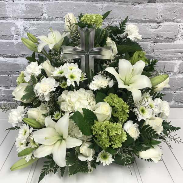 White floral arrangement with a clear cross centerpiece