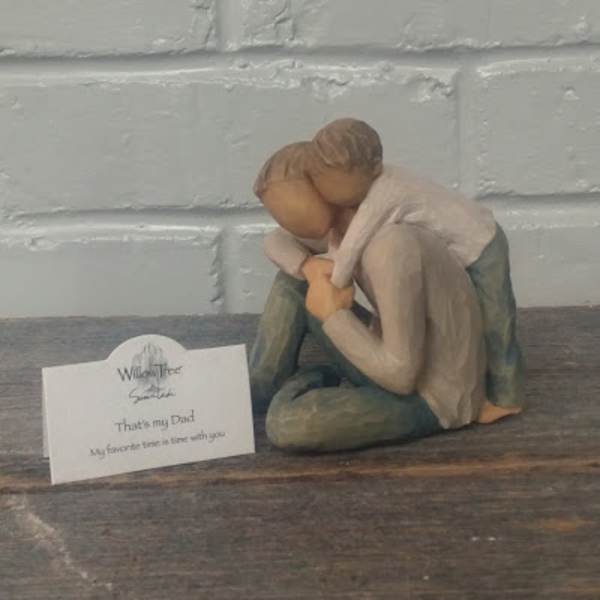 Small figurine of two people hugging beside a sympathy card
