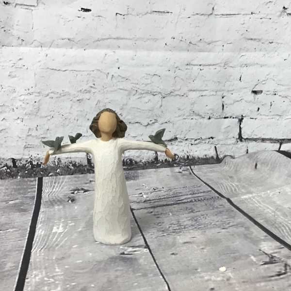 Small angel figurine in a white dress with outstretched arms