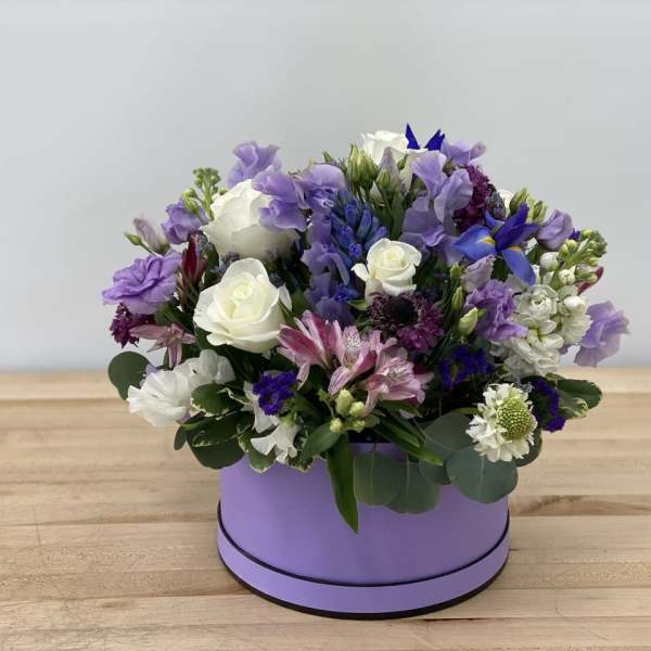 Purple and white mixed flower arrangement in a lavender box