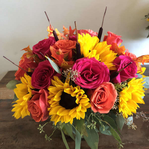 Bouquet of bright roses and sunflowers in a low arrangement