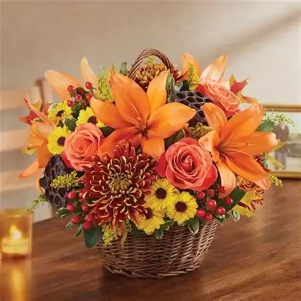 Basket arrangement of orange lilies, roses, and yellow mums