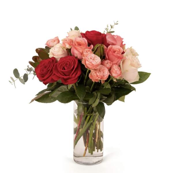Bouquet of red, pink, and white roses in a clear glass vase