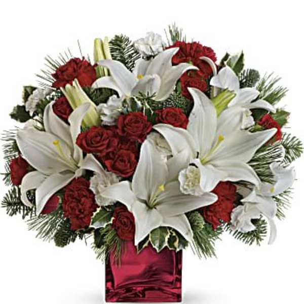 Red roses and white lilies arranged in a red glass vase