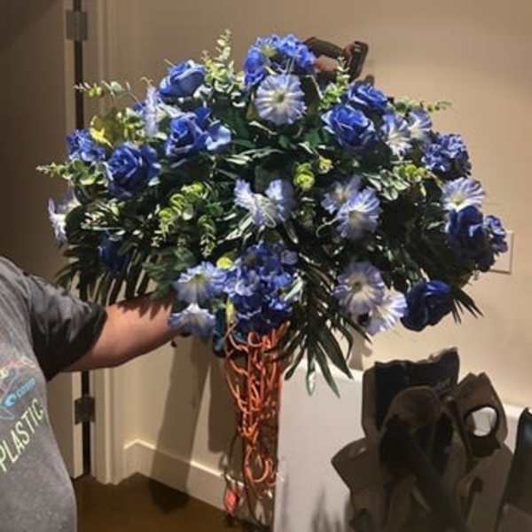 Large blue floral arrangement with roses and daisy-like blooms