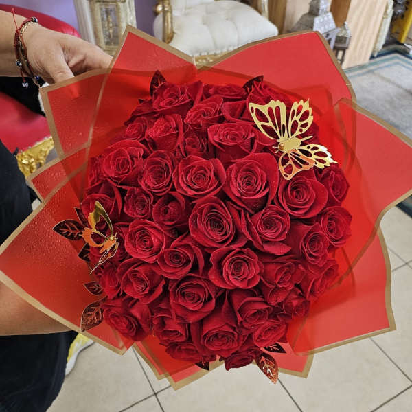 Bouquet of red roses wrapped in red paper with gold butterfly accents