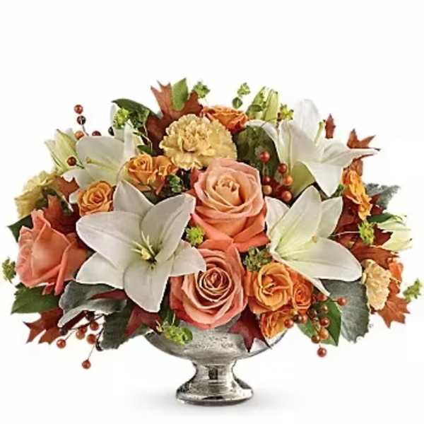 Autumn floral arrangement with roses, lilies, and carnations in a silver vase