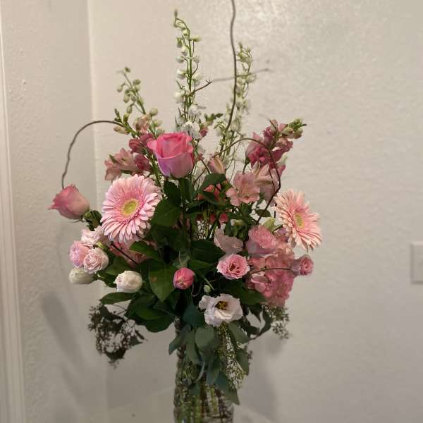 Pink mixed flower arrangement in a clear glass vase