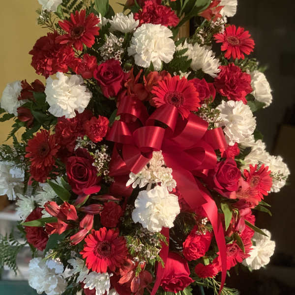 Large bouquet of red and white flowers with a red ribbon