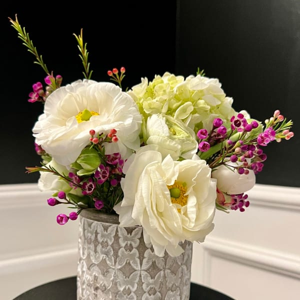 White flowers and pink filler in a textured silver vase
