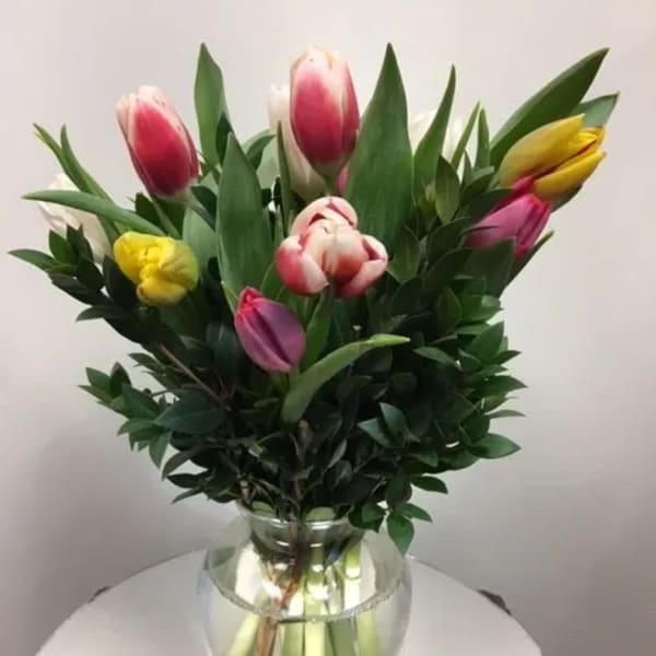 Bouquet of multicolored tulips in a clear glass vase