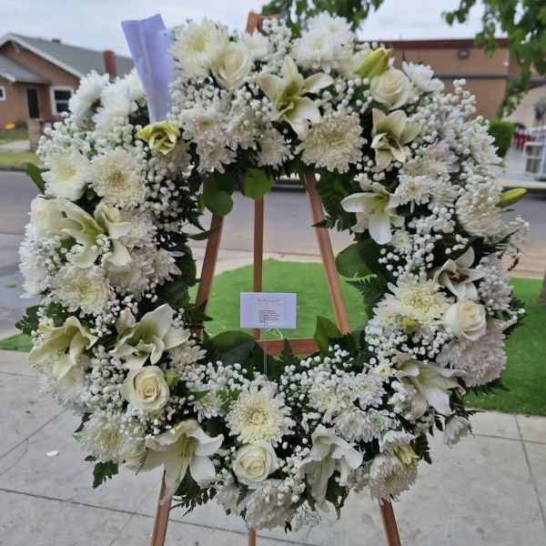 Large white floral wreath on a wooden easel