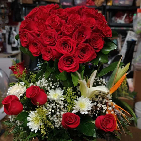Large bouquet of red roses with white flowers in a wooden container