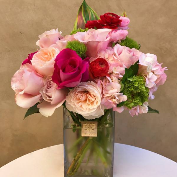 Pink and red rose bouquet in a square glass vase