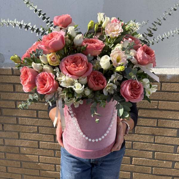 Pink roses and white blooms in a pink hatbox with pearl trim
