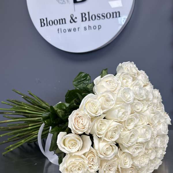 Large bouquet of white roses with dark green foliage