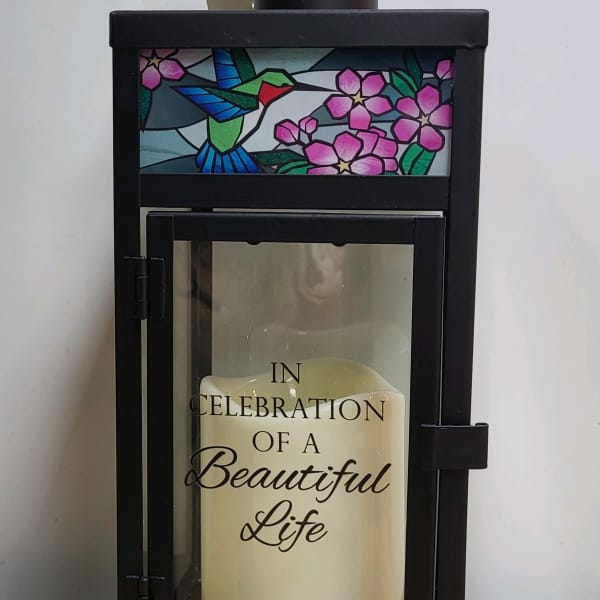 Black memorial lantern with a candle and "In Celebration of a Beautiful Life" text