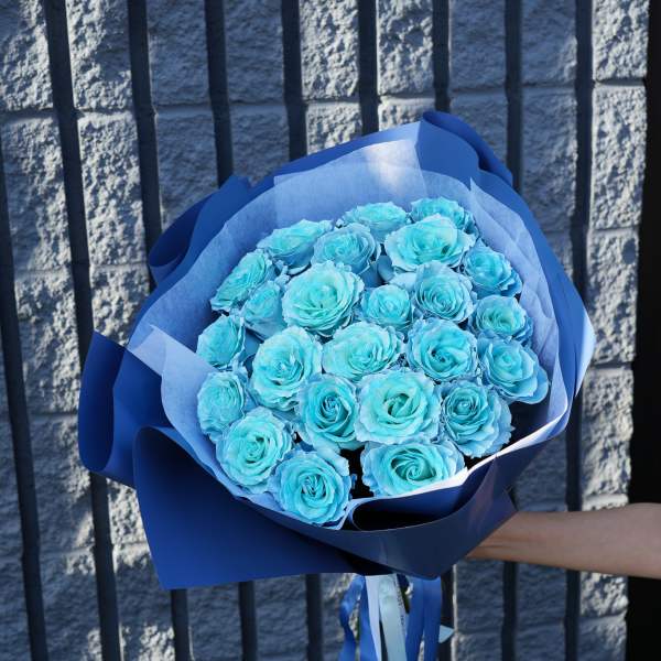 Bouquet of blue roses wrapped in blue paper